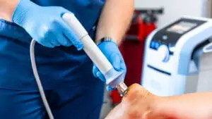 DOCTOR APPLIES SHOCKWAVE THERAPY-CLOSE UP-2